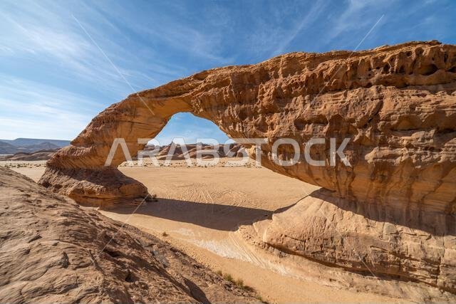 تُحيط المناظر الطبيعية الصحراوية البانورامية قرب العلا بقوس قوس قزح المذهل، وهو تكوين صخري رملي رائع، يُعدّ من عجائب التكوينات الجيولوجية في المملكة العربية السعودية. تُحيط المناظر الطبيعية الصحراوية البانورامية قرب العلا بقوس قوس قزح المذهل، وهو تكوين صخري رملي رائع، يُعدّ من عجائب التكوينات الجيولوجية في المملكة العربية السعودية.