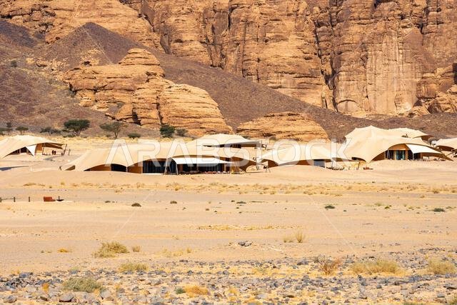 تُشكّل التكوينات الرملية في وادي آشر خلفيةً خلابةً للمنتجعات الفاخرة ضمن المناظر الصحراوية المذهلة في العلا، المملكة العربية السعودية. تُشكّل التكوينات الرملية في وادي آشر خلفيةً خلابةً للمنتجعات الفاخرة ضمن المناظر الصحراوية المذهلة في العلا، المملكة العربية السعودية.