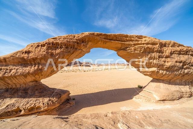 تُحيط المناظر الطبيعية الصحراوية البانورامية قرب العلا بقوس قوس قزح المذهل، وهو تكوين صخري رملي رائع، يُعدّ من عجائب التكوينات الجيولوجية في المملكة العربية السعودية. تُحيط المناظر الطبيعية الصحراوية البانورامية قرب العلا بقوس قوس قزح المذهل، وهو تكوين صخري رملي رائع، يُعدّ من عجائب التكوينات الجيولوجية في المملكة العربية السعودية.