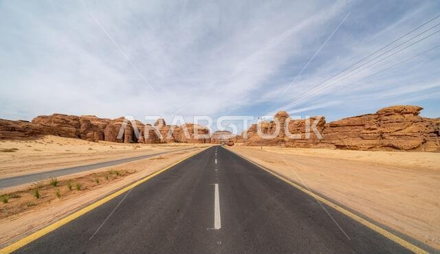 يُبرز الطريق الصحراوي الخلاب بين العلا وتبوك في المملكة العربية السعودية تكوينات صخرية رملية مذهلة وإطلالة بانورامية خلابة.