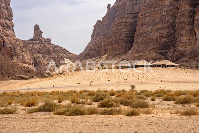 تُشكّل التكوينات الرملية في وادي آشر خلفيةً خلابةً للمنتجعات الفاخرة ضمن المناظر الصحراوية المذهلة في العلا، المملكة العربية السعودية.