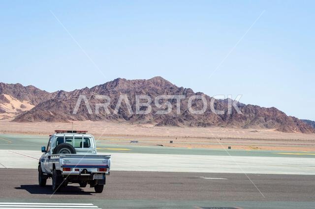 Alula, Saudi Arabia, April 5, 2024. View of a vehicle at Alula airport with rock mountains at background in a sunny day.