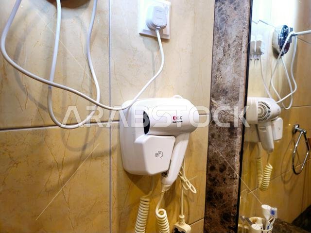 Mecca, Saudi Arabia, June 26 2024: A hair dryer inside a bathroom of hotel in Makkah city,