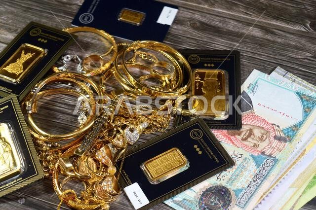 القاهرة، مصر، 17 يوليو 2025: عملة الريال السعودي، وسبائك ذهب أصفر عيار 24 قيراطًا من مركز تداول سبائك البيتكوين، ومجموعة مجوهرات من الذهب