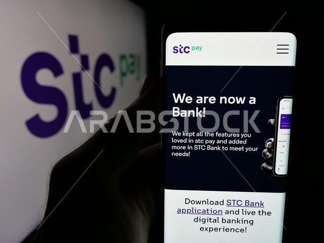 Stuttgart, Germany - 06-13-2025: Person holding smartphone with web page of Saudi Arabian digital secure wallet STC Pay on screen in front of logo. Stuttgart, Germany - 06-13-2025: Person holding smartphone with web page of Saudi Arabian digital secure wallet STC Pay on screen in front of logo.