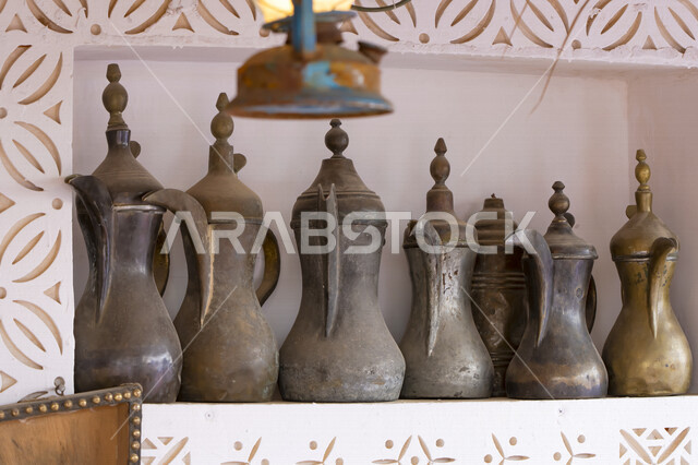 مجموعة من أباريق القهوة العربية الشرقية القديمة مصنوعة من النحاس بأسلوب تقليدي ، تراثيات سعودية ، قطع أنتيكة نحاسية في إحدى متاحف المملكة العربية السعودية