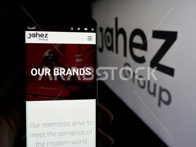 Stuttgart, Germany - 06-13-2025: Person holding cellphone with webpage of Saudi Arabian technology company Jahez Group on screen in front of logo.