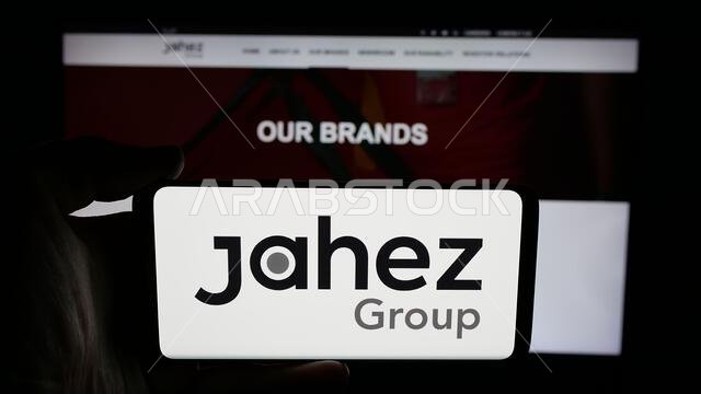 شتوتغارت، ألمانيا - 13-06-2025: شخص يحمل هاتفًا محمولًا عليه شعار شركة التكنولوجيا السعودية "مجموعة جاهز" على الشاشة أمام صفحة الويب.
