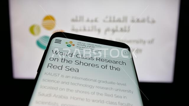 Stuttgart, Germany - 06-14-2025: Mobile phone with website of Saudi King Abdullah University (KAUST) on screen in front of logo.