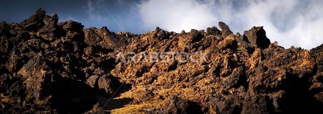 A moon landscape with lava formations, volcanic mountains, volcanoes and desert at sunset. A moon landscape with lava formations, volcanic mountains, volcanoes and desert at sunset.