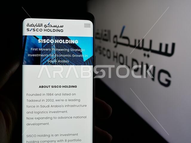 شتوتغارت، ألمانيا - 14-06-2025: شخص يحمل هاتفًا ذكيًا يعرض صفحة ويب لشركة "ساستيند إنفراستركتشر هولدينغ" (SISCO) أمام شعارها.