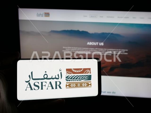 Stuttgart, Germany - 06-14-2025: Person holding smartphone with logo of Saudi tourism investment company ASFAR on screen in front of website. Stuttgart, Germany - 06-14-2025: Person holding smartphone with logo of Saudi tourism investment company ASFAR on screen in front of website.