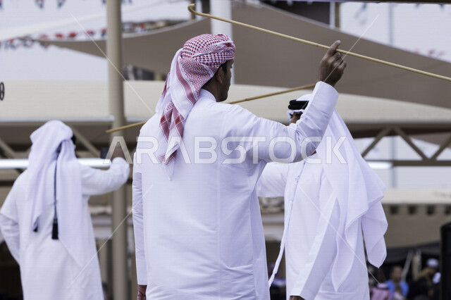 A group of Emirati Gulf Arab men dance the Ayala dance (stick dance) in the entertainment events of the Janadriyah Festival in 2018, a traditional folk dance, a heritage festival in Riyadh in the Kingdom of Saudi Arabia, folk dance and national identity.