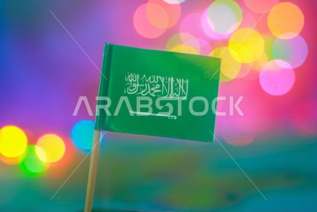 Colorful bokeh lights behind Saudi Arabian flag. Ideal for national celebration, Middle East identity & positive unity in modern visual storytelling.