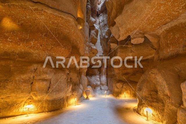 أضواء دافئة تضيء جدران الحجر الرملي داخل كهوف جبل القره، وهي أعجوبة جيولوجية في الأحساء، شرق المملكة العربية السعودية، مما يخلق أضواء دافئة تضيء جدران الحجر الرملي داخل كهوف جبل القره، وهي أعجوبة جيولوجية في الأحساء، شرق المملكة العربية السعودية، مما يخلق