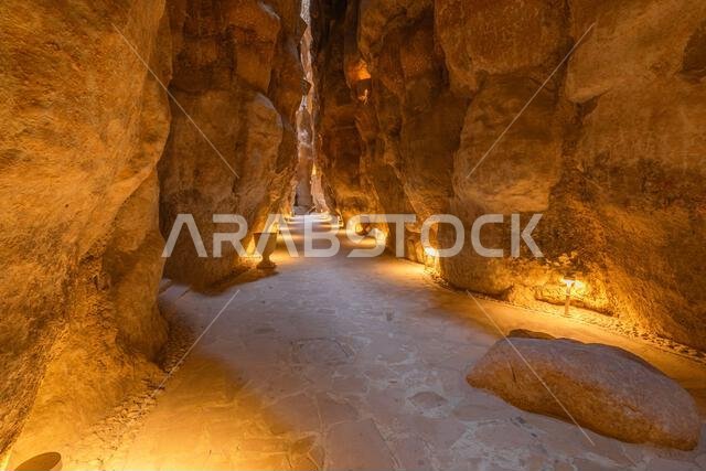 أضواء دافئة تضيء ممرًا في نظام كهوف الحجر الرملي في جبل القره بمدينة الأحساء في المملكة العربية السعودية، مما يخلق جوًا ساحرًا أضواء دافئة تضيء ممرًا في نظام كهوف الحجر الرملي في جبل القره بمدينة الأحساء في المملكة العربية السعودية، مما يخلق جوًا ساحرًا
