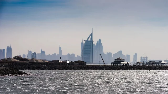 أفق مدينة دبي وفندق برج العرب فوق مياه البحر اللامعة