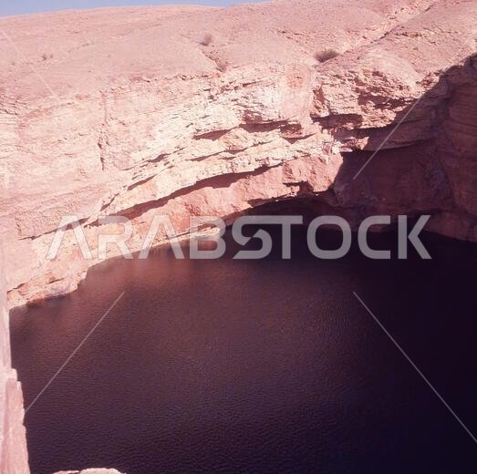 1960s, historical, view from above of a deep water pool at the Al-Kharj Oasis, Saudi Arabia, an area known as a 'water land' due to its many natural springs. As the land was fertile and could support agricutural production, Al-Kharj was selected in 1938 as the site to establish a government experimental farm, which subsequently developed into a major food producing area for cerals, dates, fruits and vegetables and later livestock and poultry. 1960s, historical, view from above of a deep water pool at the Al-Kharj Oasis, Saudi Arabia, an area known as a 'water land' due to its many natural springs. As the land was fertile and could support agricutural production, Al-Kharj was selected in 1938 as the site to establish a government experimental farm, which subsequently developed into a major food producing area for cerals, dates, fruits and vegetables and later livestock and poultry.