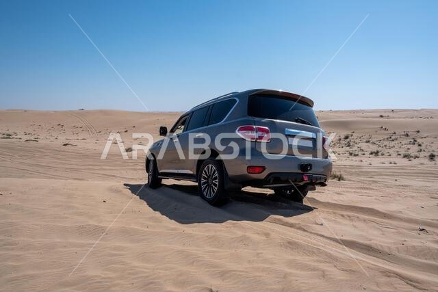 SUV four wheel drive vehicle car Al Qudra empty quarter seamless desert sahara in Dubai UAE middle east with wind paths and sand hills gray cloudy sky