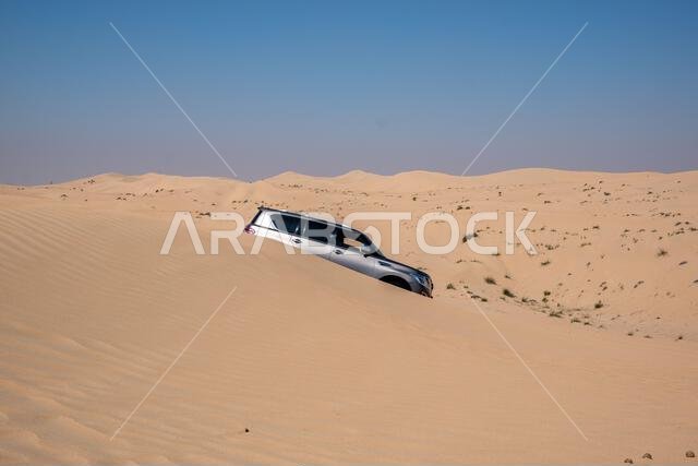 SUV four wheel drive vehicle car Al Qudra empty quarter seamless desert sahara in Dubai UAE middle east with wind paths and sand hills gray cloudy sky