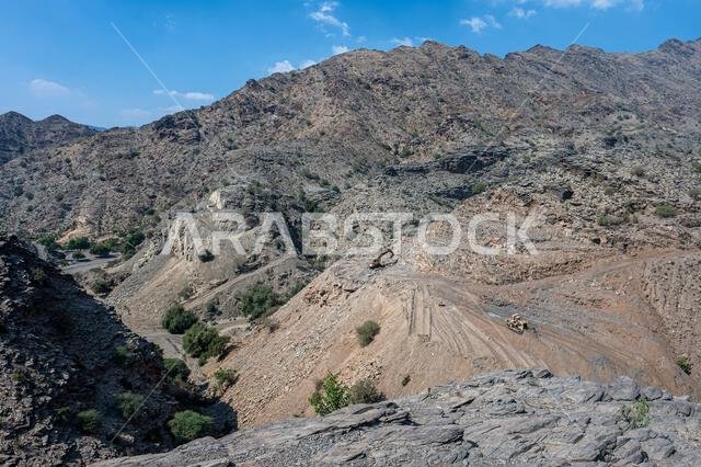Heavy machinery in the process of mountain road construction works in Saudi Arabia