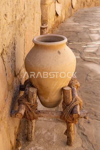Middle East, Saudi Arabia, Tabuk Province, Tayma. An amphora on a stand at a desert oasis.