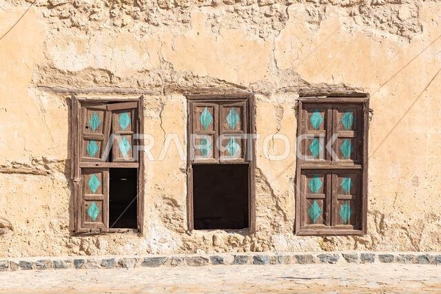 الشرق الأوسط، المملكة العربية السعودية، تبوك، دبي. مصاريع نوافذ خشبية على مبنى قديم في مدينة دبي الساحلية.