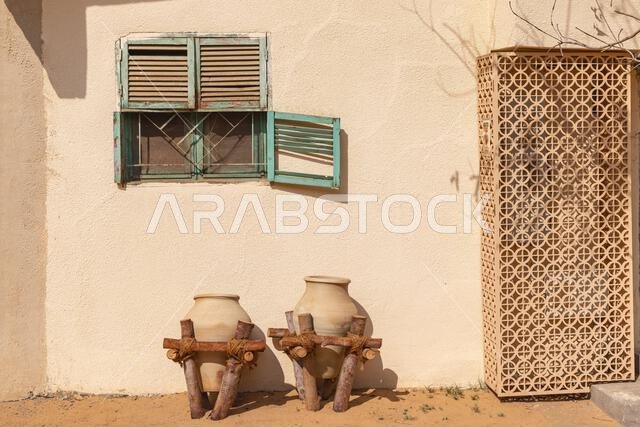 الشرق الأوسط، المملكة العربية السعودية، المدينة المنورة، العلا. جرة فخارية على حامل أمام مبنى في البلدة القديمة في العلا.