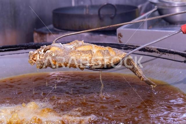 Middle East, Saudi Arabia, Madinah Province, Medina.  Fresh fish cooking at a market in Medina.