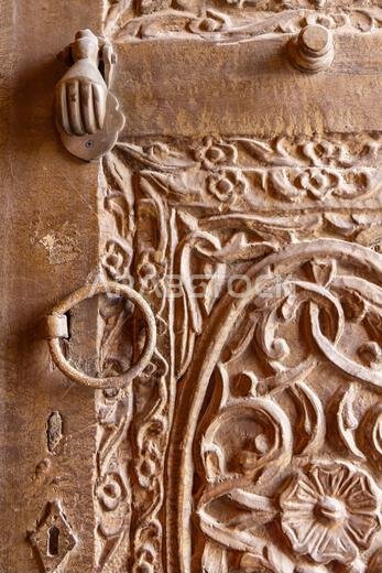 Middle East, Saudi Arabia, Mecca, Jeddah, Al-Balad. Metal pull and knocker on a carved wooden door in the Al-Balad historical district.