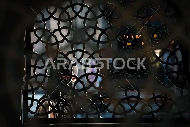 فتاة مسلمة خلف السياج المزخرف.