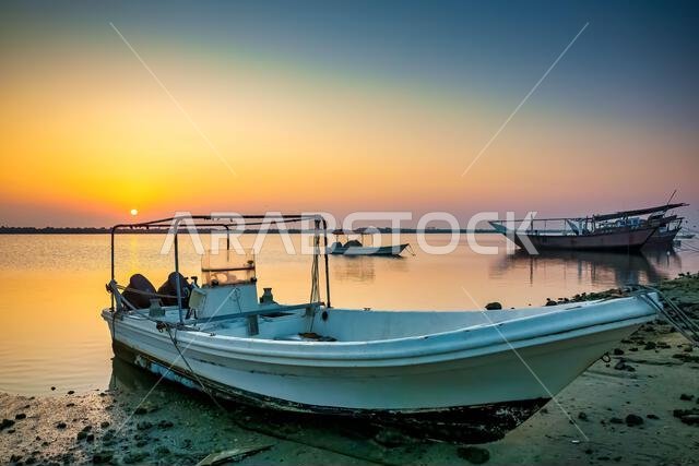 Golden sunrise in Dammam Corniche,Saudi Arabia: Peaceful waters and boats embraced by the morning light.