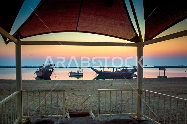 Golden sunrise in Dammam Corniche,Saudi Arabia: Peaceful waters and boats embraced by the morning light. Golden sunrise in Dammam Corniche,Saudi Arabia: Peaceful waters and boats embraced by the morning light.