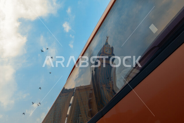 صورة لانعكاس برج الساعة على نافذة زجاجية ، أبراج الحرم المكي الشريف ، الفن الهندسي المعماري في السعودية ، معالم دينية اسلامية 