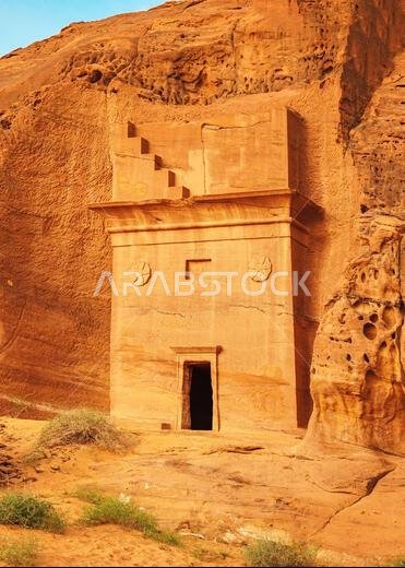 Old Nabatean architecture carved on orange sandstone wall at Jabal Al Ahmar, Hegra in Saudi Arabia, 18 ancient tombs are located here, 111 in whole Ma Old Nabatean architecture carved on orange sandstone wall at Jabal Al Ahmar, Hegra in Saudi Arabia, 18 ancient tombs are located here, 111 in whole Ma