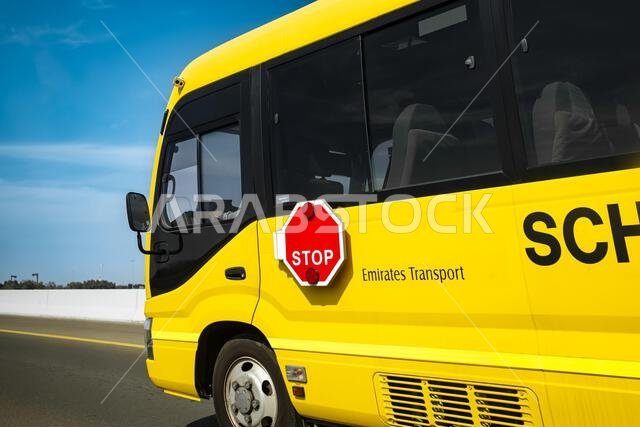 School bus driving in Dubai city, United Arab Emirates. A yellow school bus driving along the road. Travel photo, nobody, copy space for text