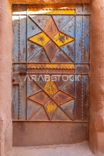 Ushaiger Heritage Village, Riyadh, Saudi Arabia, Middle East. Painted metal door on an old mud brick building in the Ushaiger Heritage Village.