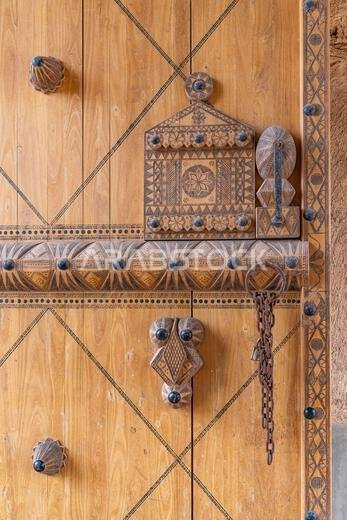 Middle East, Saudi Arabia, Al-Qassim, Unaizah. Decoratively carved wooden door in Unaizah.
