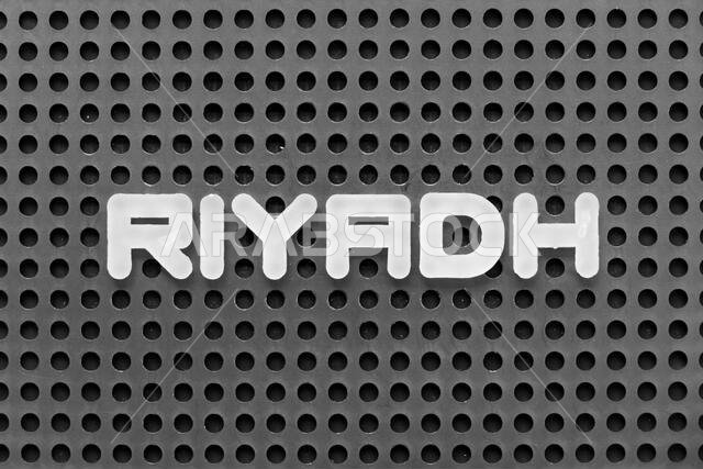 White alphabet letter in word riyadh on black pegboard background White alphabet letter in word riyadh on black pegboard background