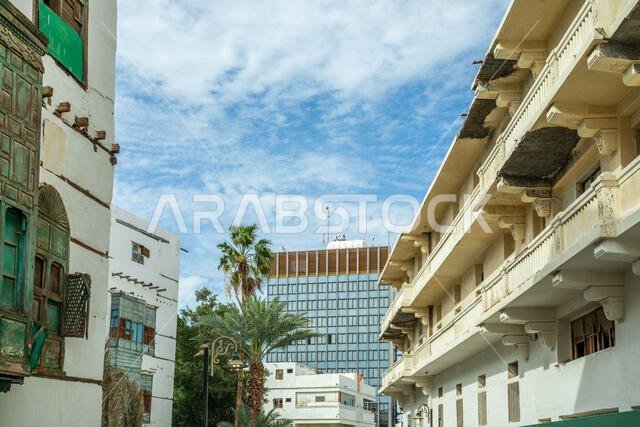 Al-Balad old town street with traditional muslim houses and modern building in the background, Jeddah, Saudi Arabia