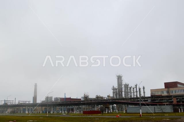 Oil refinery, petrochemical plant, in cloudy weather, fog.