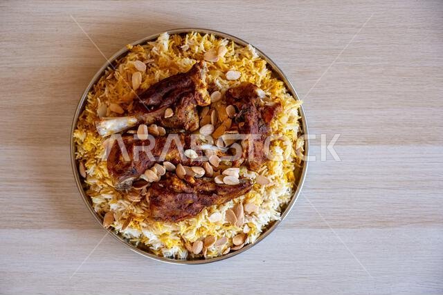 طبق من اللحم والأرز مغطى باللوز على طاولة خشبية مع منظر علوي