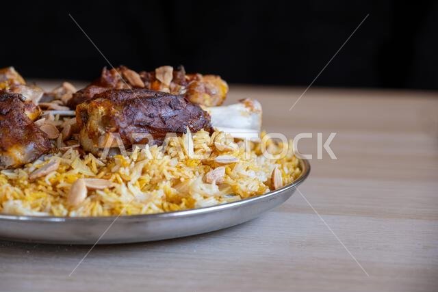 طبق من اللحم والأرز مغطى باللوز على طاولة خشبية مع منظر علوي