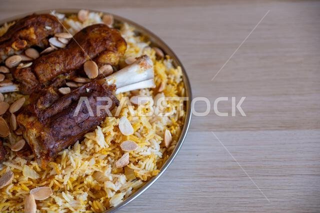 طبق من اللحم والأرز مغطى باللوز على طاولة خشبية مع منظر علوي