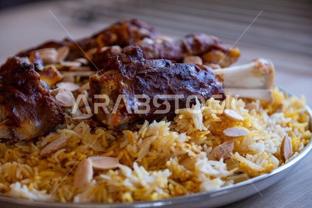 Plate of meat and rice topped with almonds on wooden table with top view Plate of meat and rice topped with almonds on wooden table with top view