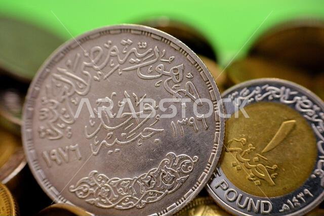 A new and old Egyptian One 1 EGP LE pound coins, a commemorative silver coin year 1976 AD, 1396 AH of King Faisal Bin AbdulAziz Al Saud and a current