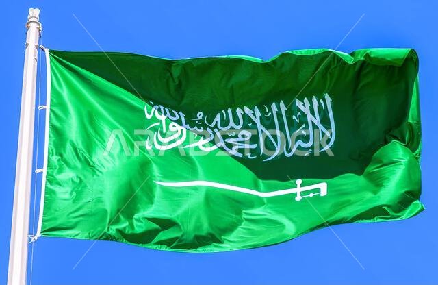 علم المملكة العربية السعودية يرفرف في مهب الريح في السماء