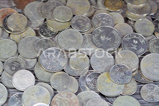 Old Saudi Arabia money coins of different eras from the kingdom of Saudi Arabia times, vintage retro old Saudi currency, value, exchange rate of the c