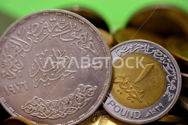 A new and old Egyptian One 1 EGP LE pound coins, a commemorative silver coin year 1976 AD, 1396 AH of King Faisal Bin AbdulAziz Al Saud and a current