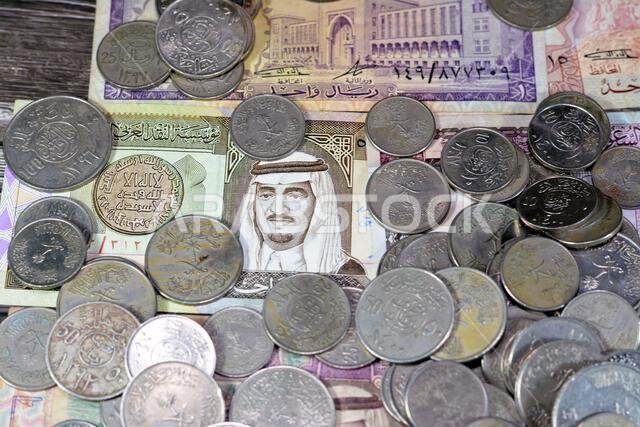 Saudi Arabia riyals money banknote bills and coins of different eras from the kingdom of Saudi Arabia times, vintage retro old Saudi currency, value,